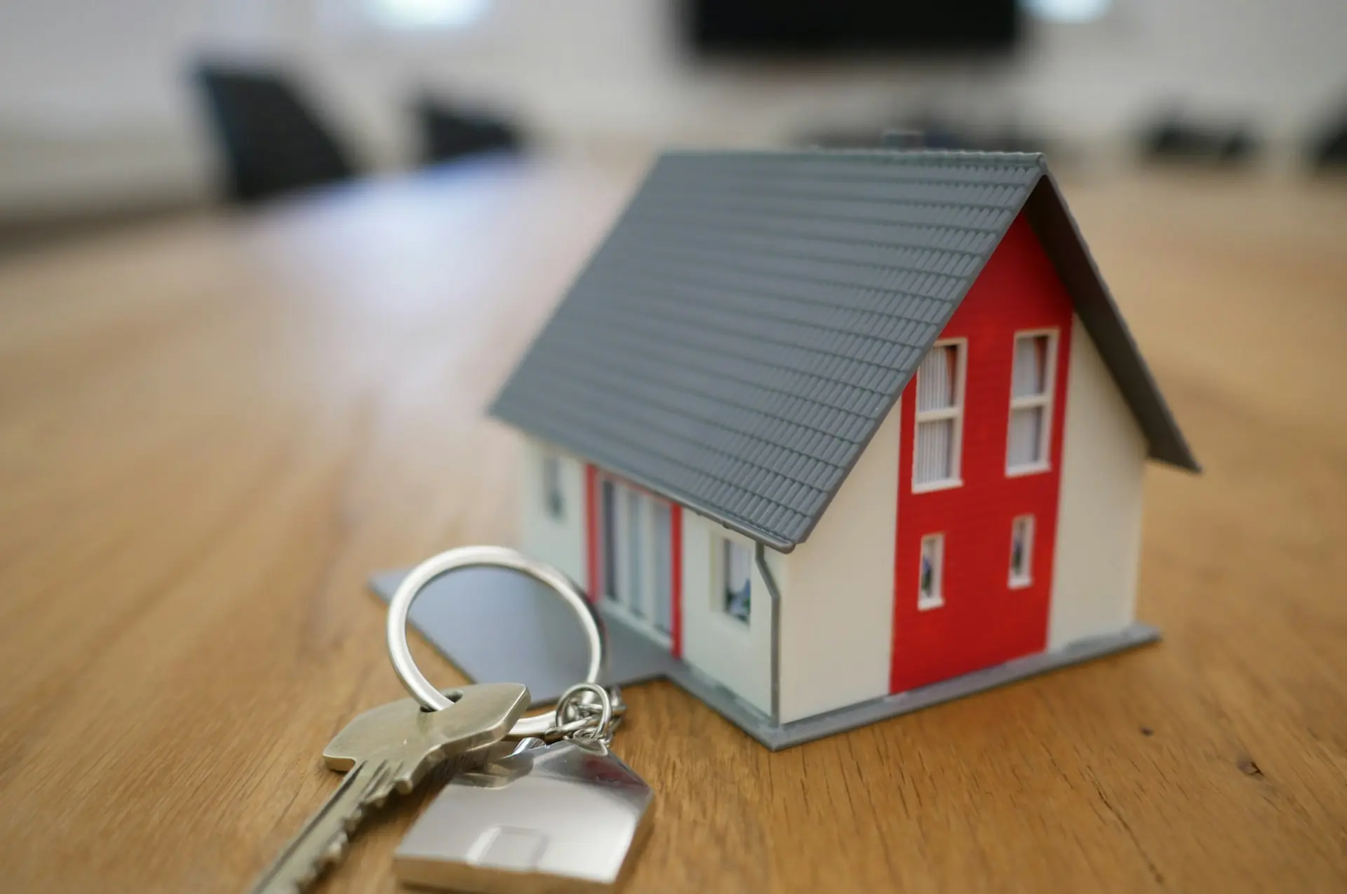 white and red wooden house miniature on brown table